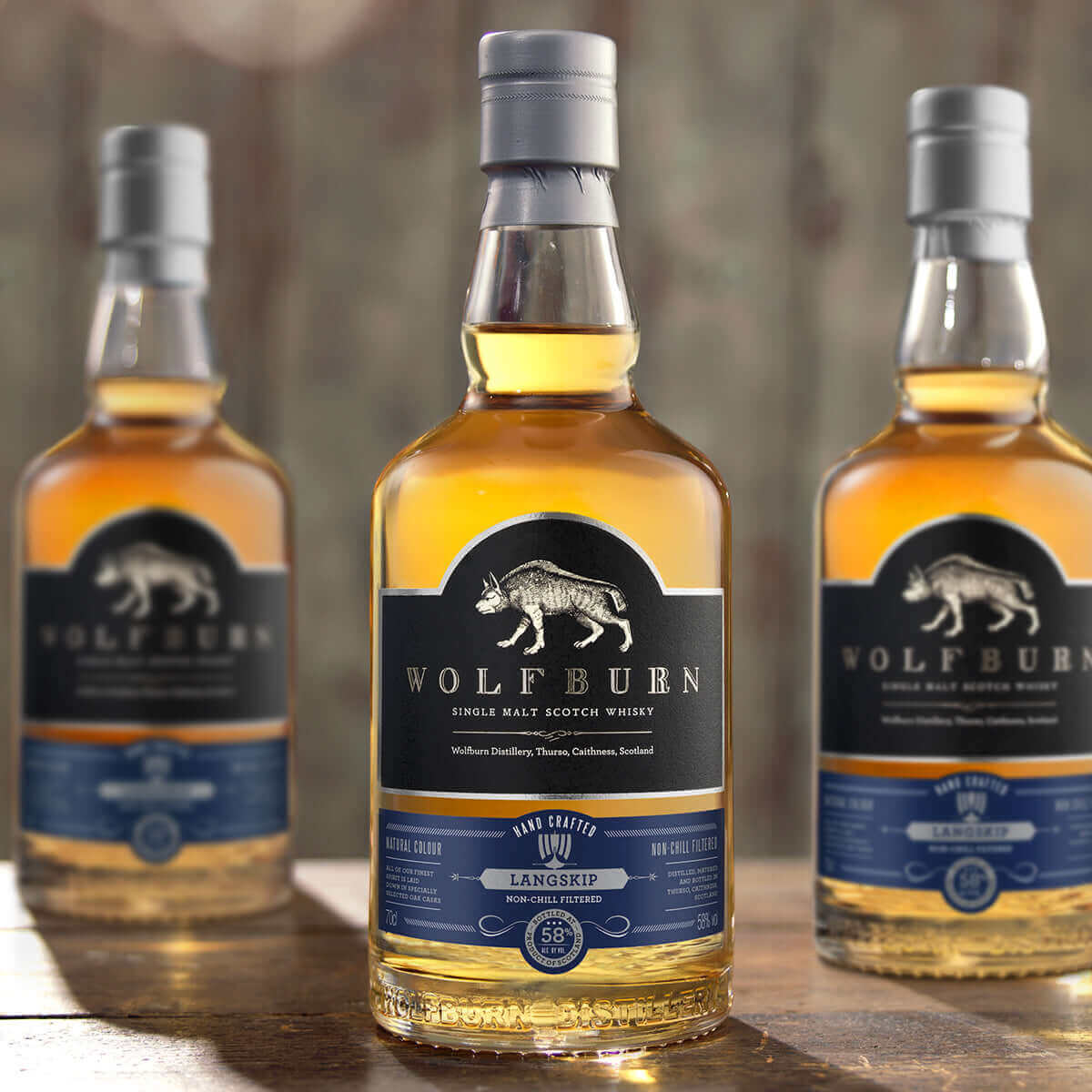 Langskip Single Malt Scotch Whisky bottles with a smooth amber color displayed in a rustic setting.