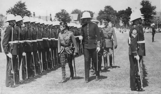Historical black-and-white photograph of The Royal Marines in uniform standing at attention to Edward Prince of Wales.