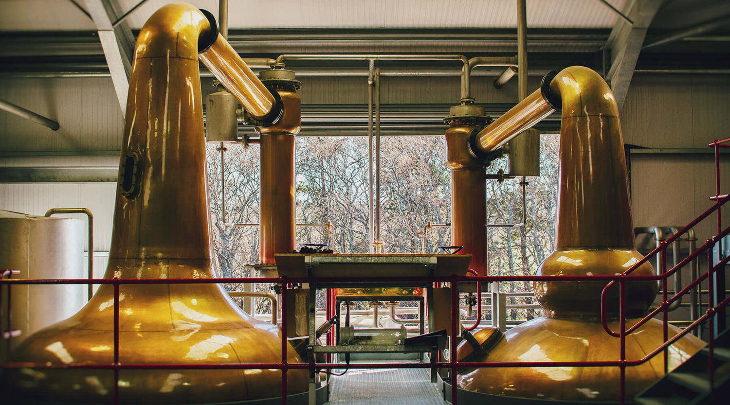 Interior of a distillery showcasing copper pot stills used for producing Miniature 5cl Single Malt Scotch Whiskies.