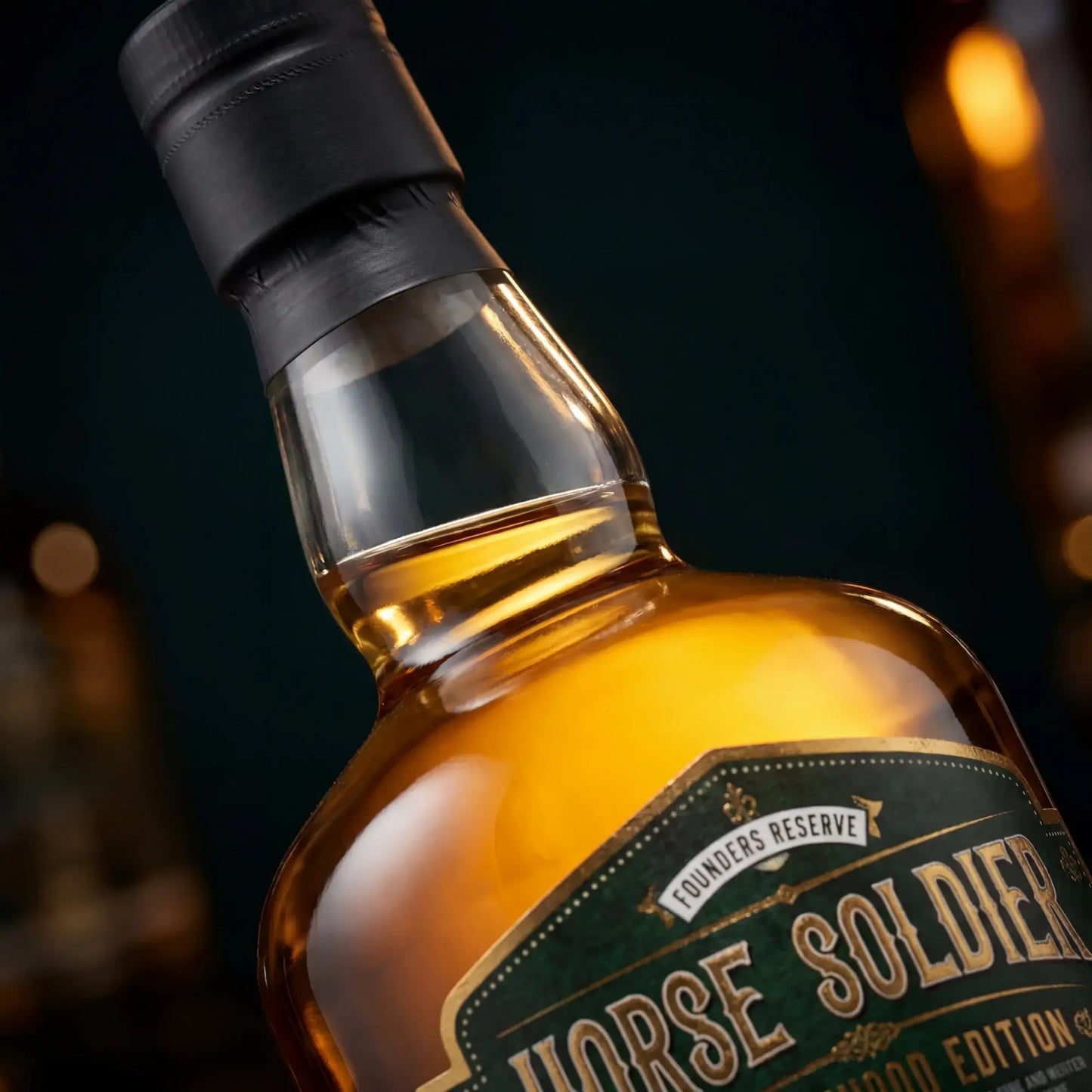 Wolfburn Horse Soldier Single Malt Scotch Whisky bottle close-up with amber liquid and black cap.
