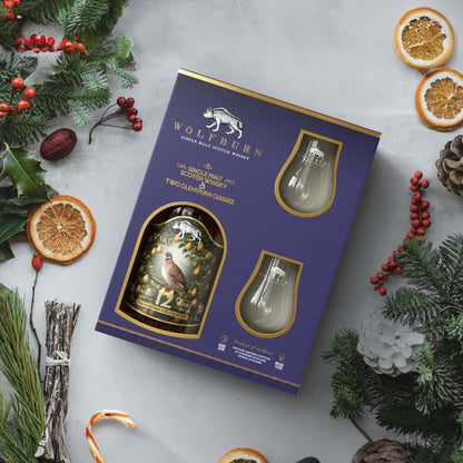 Wolfburn whisky gift set with Christmas decorations on a light gray background