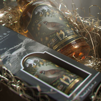 Whisky bottle with decorative label in a gift box on a textured surface