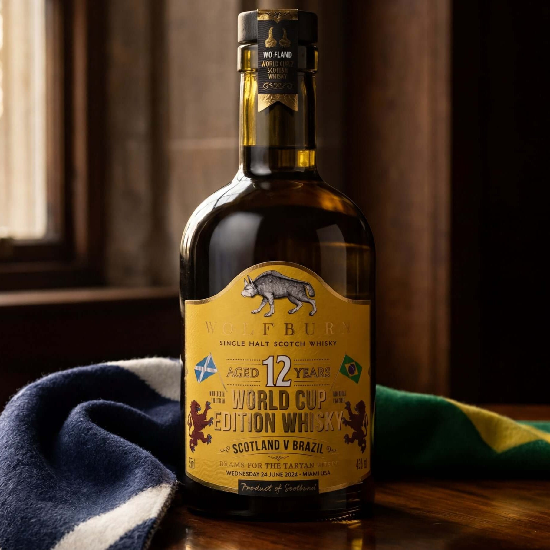 Bottle of 12-year-old World Cup Edition Single Malt Scotch Whisky on a wooden surface with a Scotland and Brazil scarf