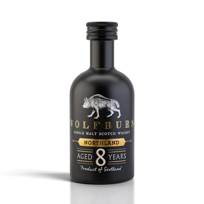 A 5cl miniature bottle of Wolfburn Northland 8 Years Single Malt Scotch Whisky, featuring a matte black bottle, silver wolf logo, and gold and white text on a clean white background.