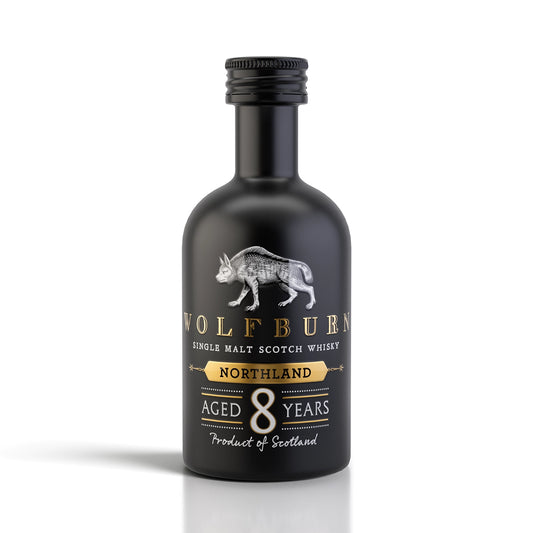 A 5cl miniature bottle of Wolfburn Northland 8 Years Single Malt Scotch Whisky, featuring a matte black bottle, silver wolf logo, and gold and white text on a clean white background.