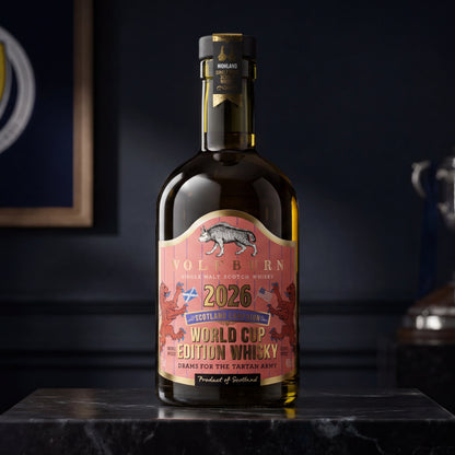 Wolfburn Morven World Cup Edition 2026 Highland Single Malt Scotch Whisky collector's bottle on marble plinth with Scotland crest and trophy in background, coral pinstripe label with Saltire and US flag