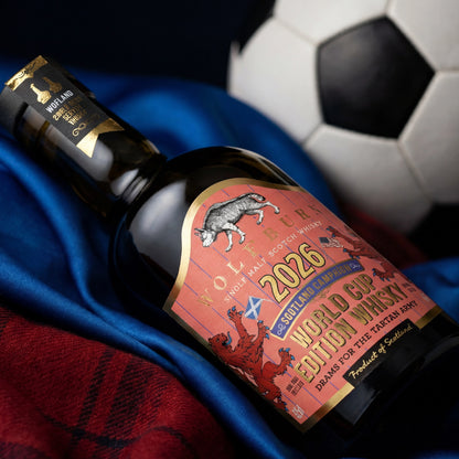 Wolfburn Morven World Cup Edition 2026 Highland Single Malt Scotch Whisky bottle resting on Scotland blue away shirt fabric with tartan and football in background