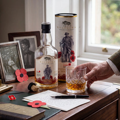 Limited edition Wolfburn Poppyscotland single malt scotch whisky beside old family photographs, Scottish poppies and a crystal glass for remembrance day