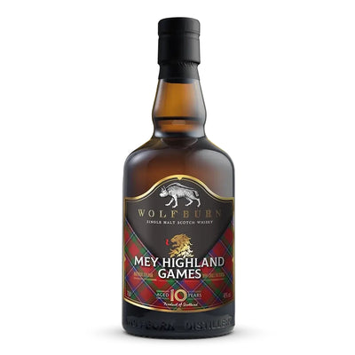 A bottle of Wolfburn 'Mey Highland Games' 10 Year Single Malt Scotch Whisky, featuring a dark amber glass bottle, black cap, and a label with a black background, white text, and red tartan Sinclair pattern.