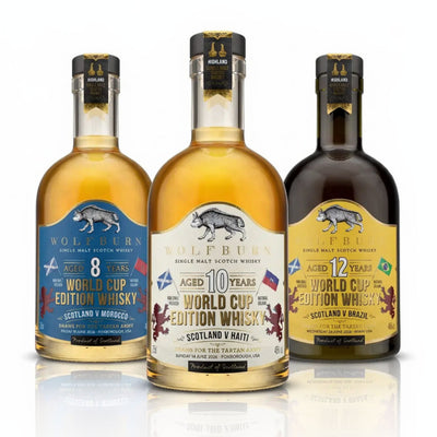 Three bottles of Wolfburn World Cup Limited Edition Single Malt Scotch Whisky with different age statement labels on a white background.